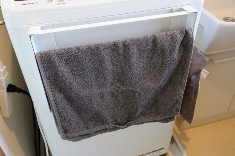 洗濯機横マグネット折り畳み棚 タワーにタオルを引っ掛けている様子